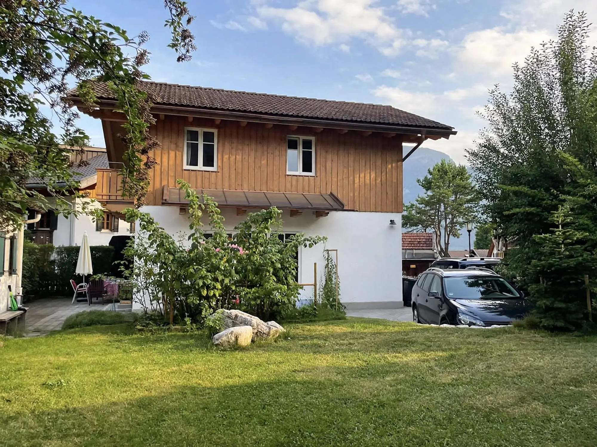 Das Ferienhaus mit Holzfassade, davor der Garten