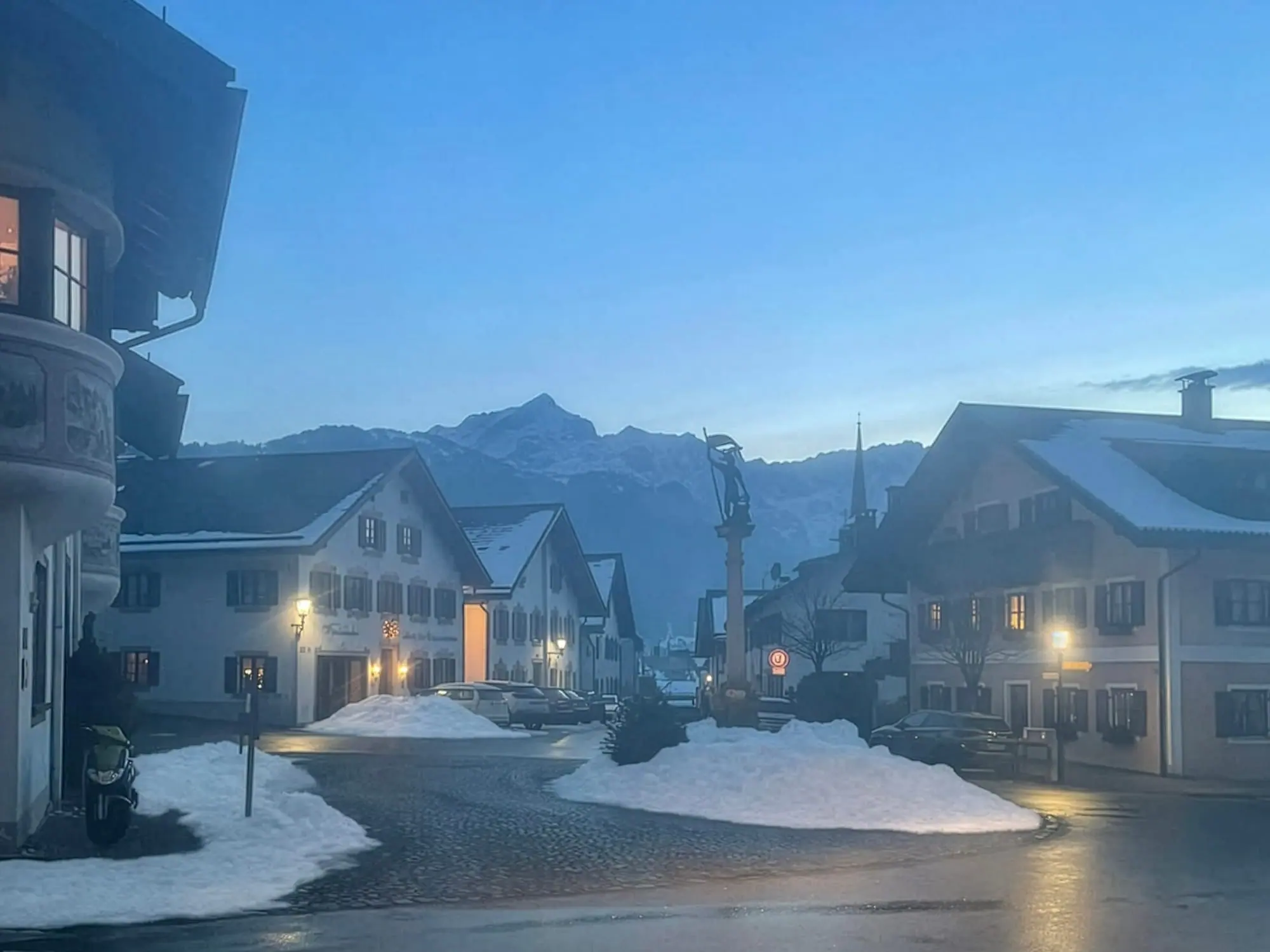 Die Ludwigstraße in Partenkirchen an einem Winterabend, dahinter die Berge