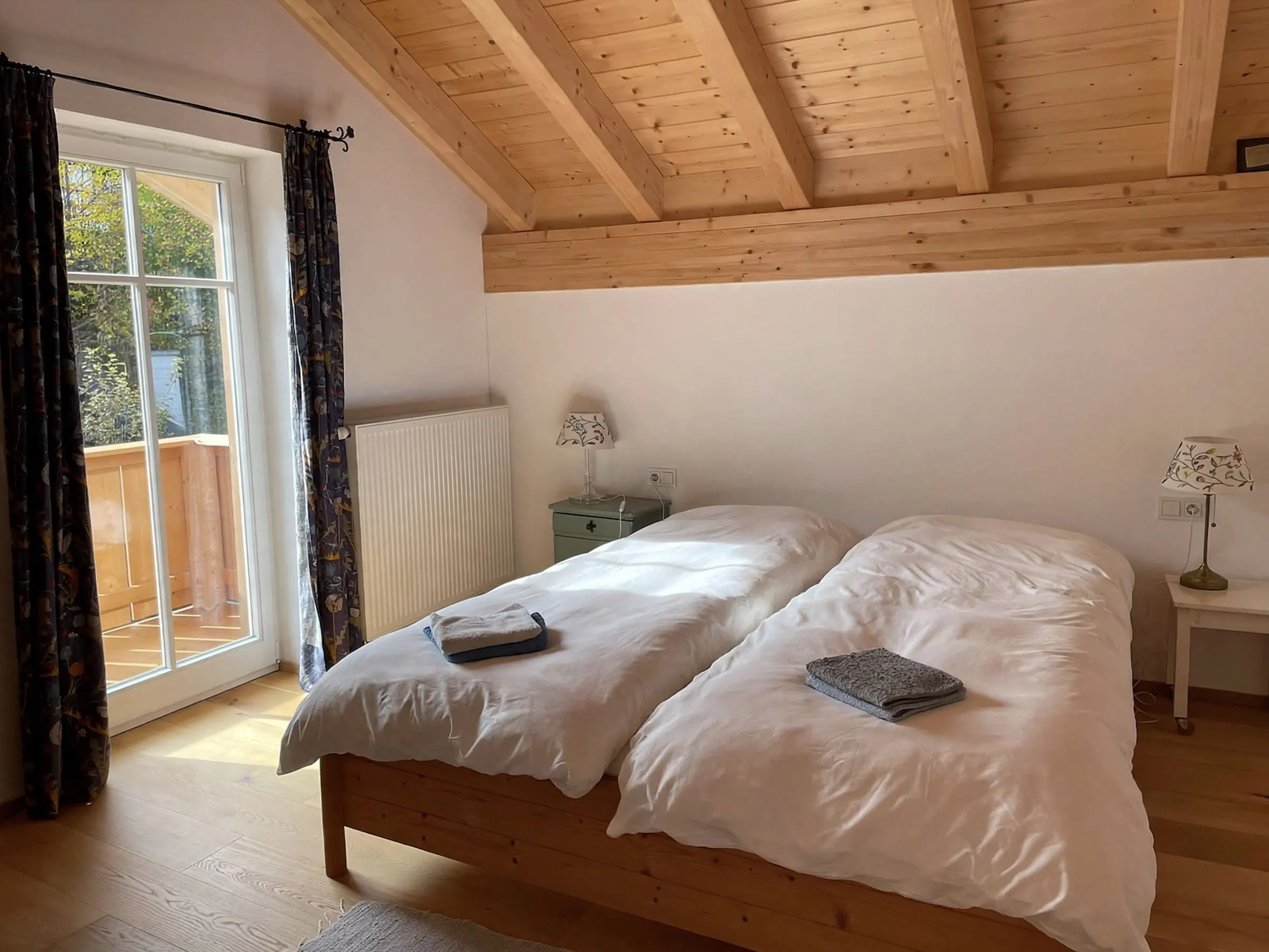 Schlafzimmer mit Doppelbett unter dem Holzdach