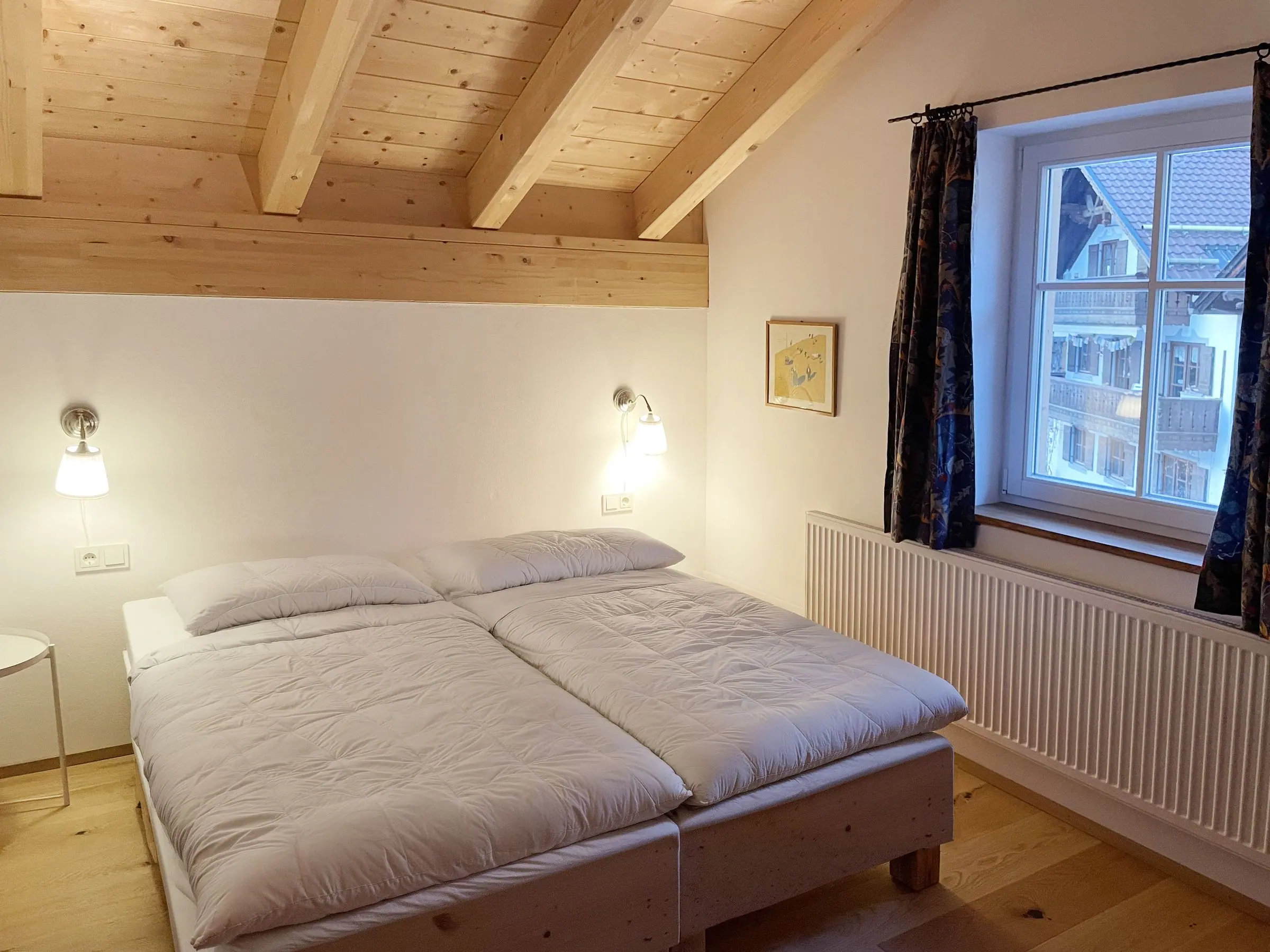 Zweites Schlafzimmer mit zwei Betten unter dem Holzdach