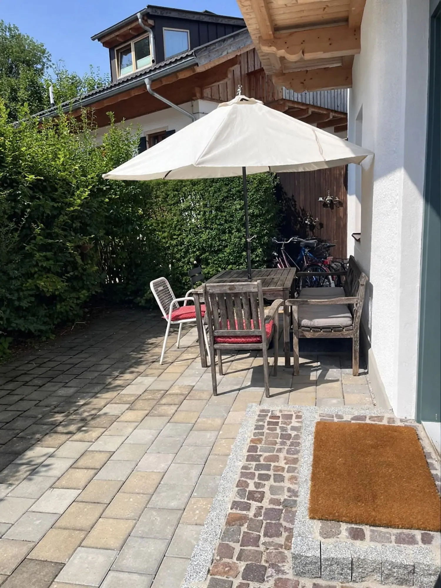 Terrasse mit Tisch, Stühlen und Sonnenschirm
